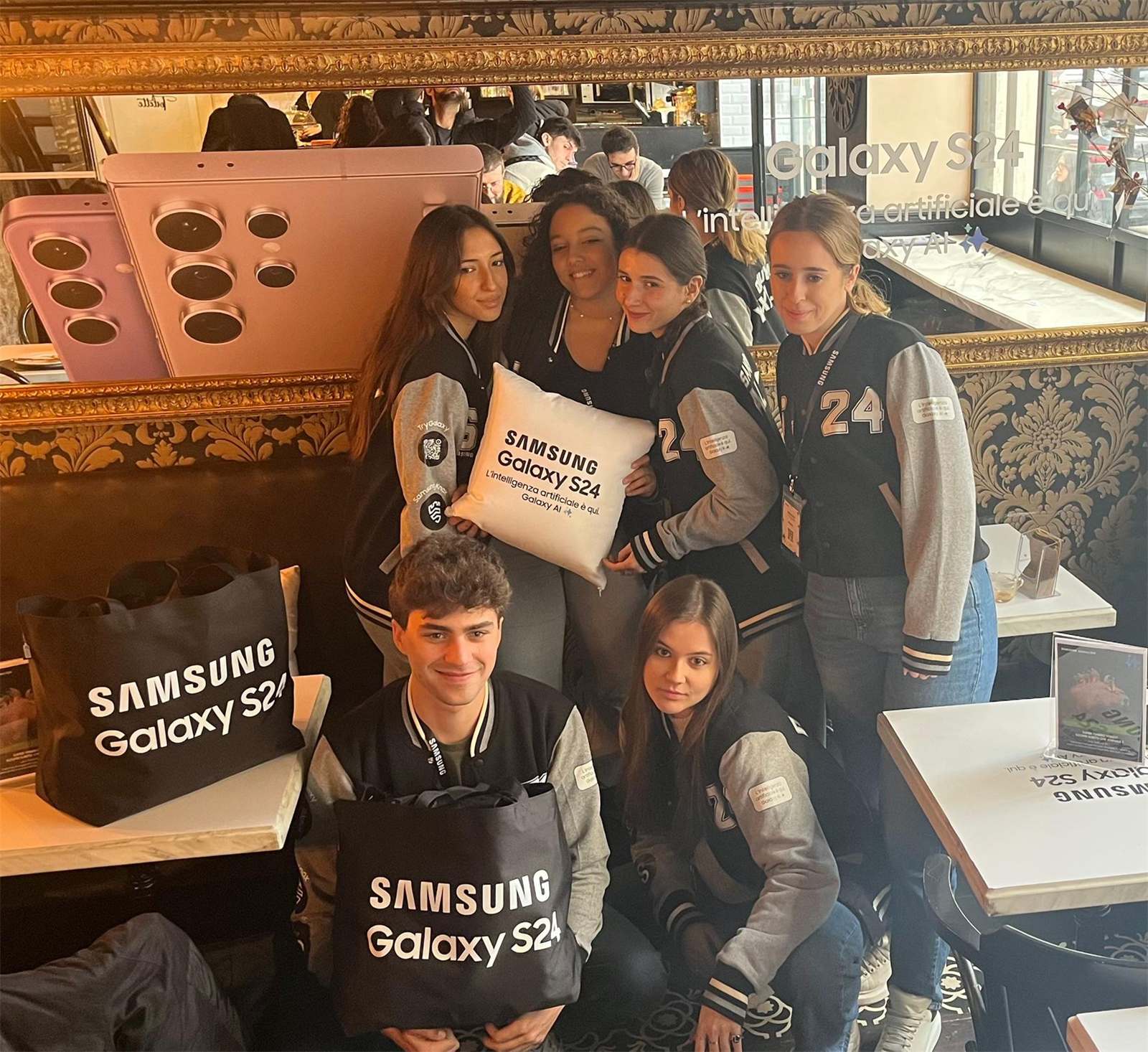 Studenti con giacche e shopper Galaxy S24 al Samsung Galaxy AI Café