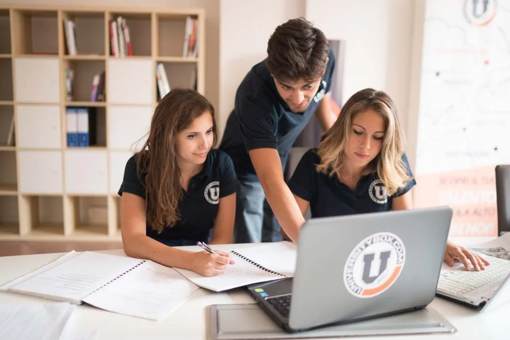 Studenti con la maglia UniversityBox al lavoro su un portatile